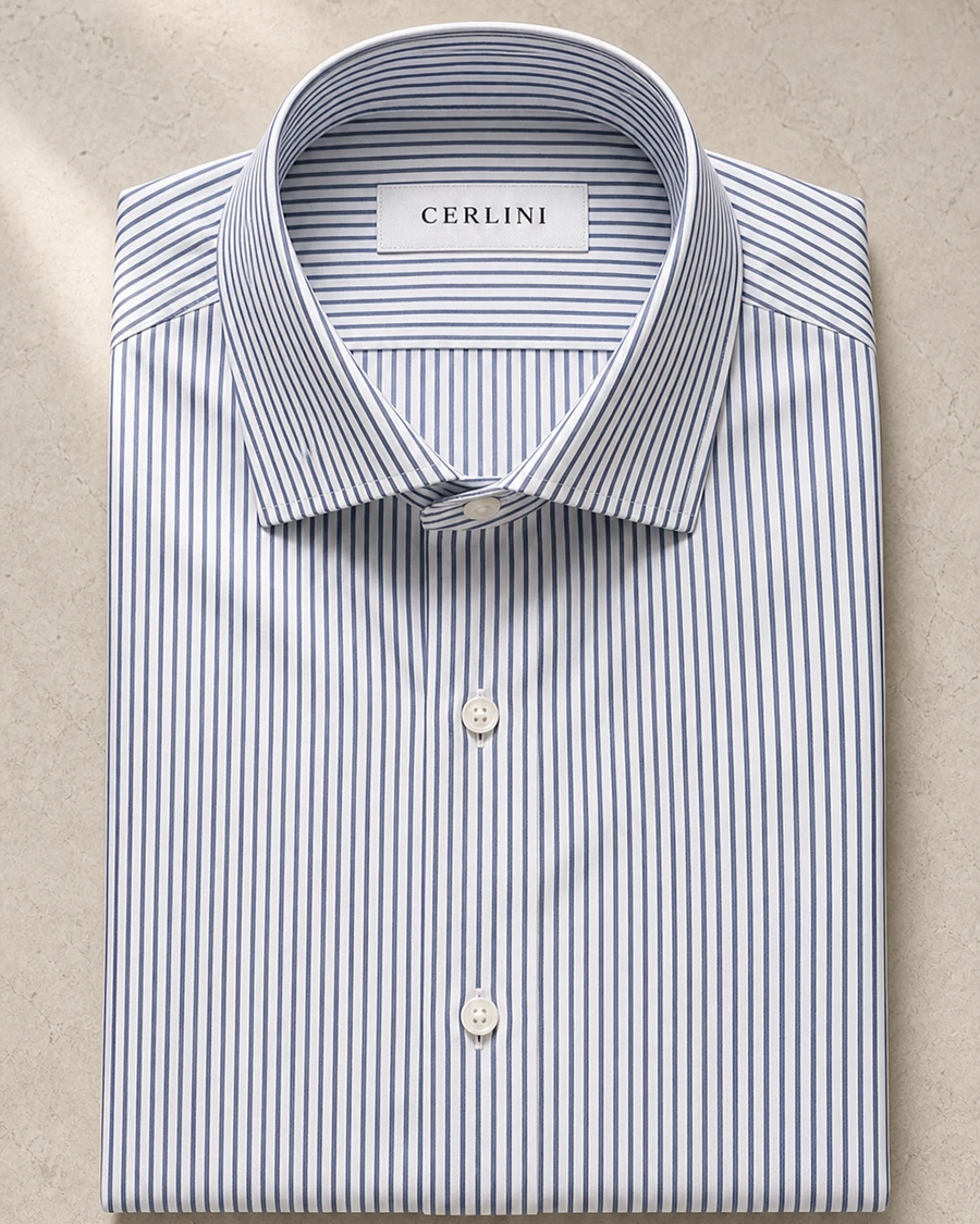 The Diplomat in a fine blue stripe, a Cerlini shirt folded against a stone surface.